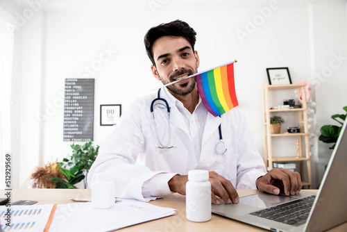LGBT health handsome doctor with rainbow flag. Bisexual, Lesbian and Transgender care concept. Work from home in the bedroom