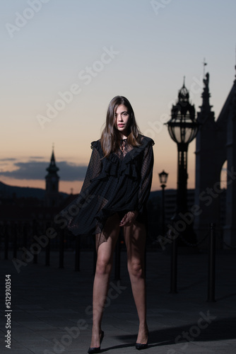 Beautiful young woman in the city street on night city backgroung. Beautiful young fashion woman. Sexy black dress. © Volodymyr