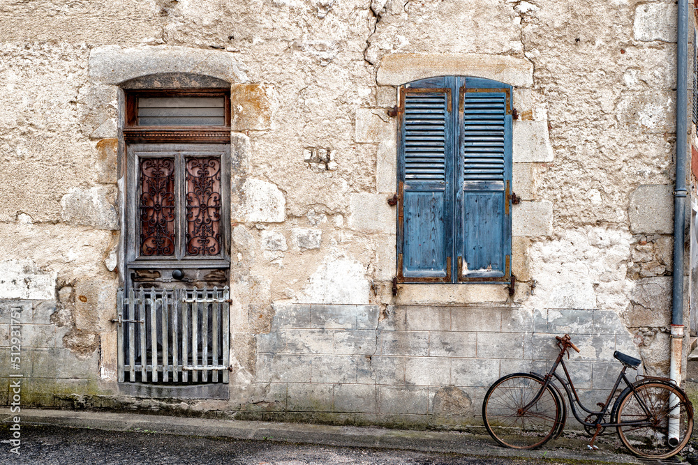 une vieille bicyclette contre la façade d'une maison