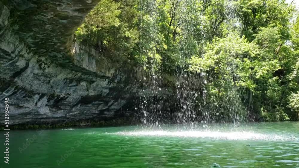 water level view waterfall spilling into blue green lake water level view waterfall spilling into blue green lake