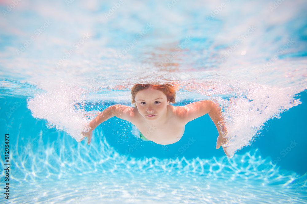 Child boy swim under water in sea. Kid swimming in pool underwater. Happy boy swims in sea underwater, active kid swimming, playing and diving, children water sport. Summer vacation concept.