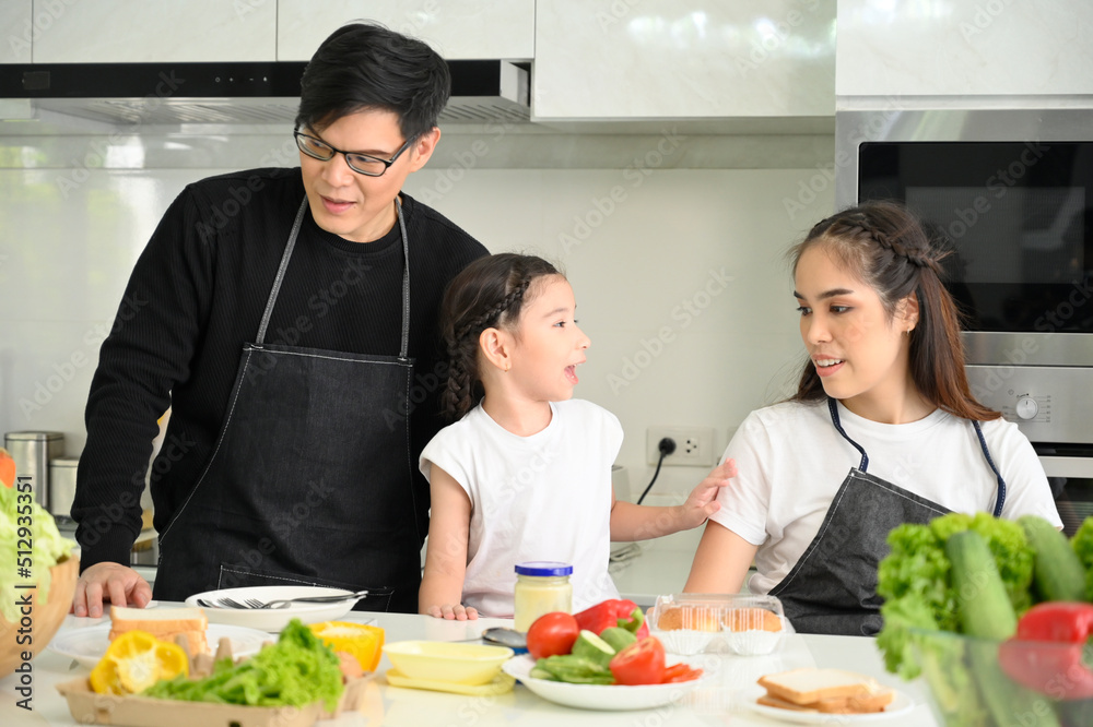 Overjoyed young family with little preschooler kids have fun cooking baking pastry at home together, happy smiling parents enjoy weekend cooking in kitchen