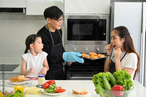 Overjoyed young family with little preschooler kids have fun cooking baking pastry at home together  happy smiling parents enjoy weekend cooking in kitchen
