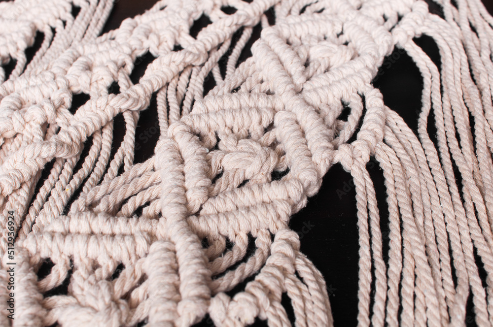 Fragment of wall decor macrame pattern on black background Fragment of wall decor macrame pattern on black background