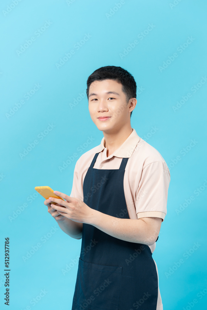 Barber man in an apron sending a message with the mobile Barber man in an apron sending a message with the mobile