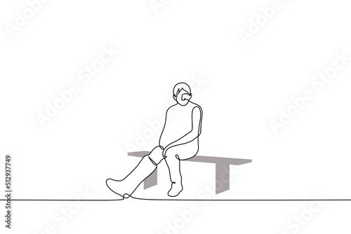 man with a cast on his right leg sadly sits alone on a bench - one line drawing vector. concept an injured athlete sits idle, a man with a broken leg on which a plaster