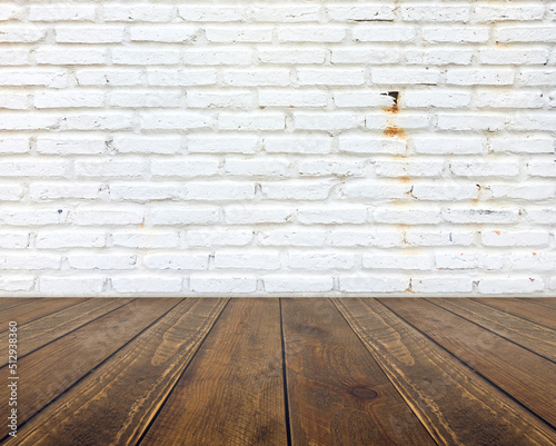 The wooden top table and the back is white Brick wall Background.