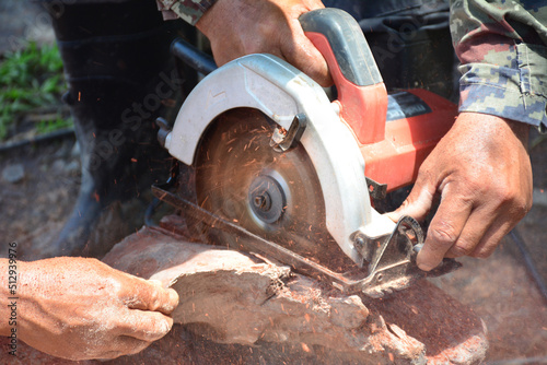 Workers use electric saws to cut wood.
