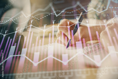 Financial forex graph displayed on hands taking notes background. Concept of research. Multi exposure © peshkova