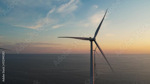 Aerial view of wind turbines at sunset. Working offshore wind farm. Concept: power plant, climate change, sustainable resources, global warming, alternative energy source, renewable energy.