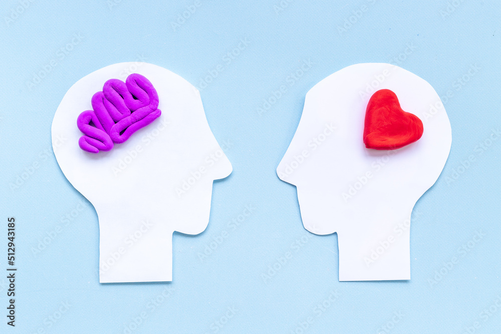 Relations and communication concept. Brain and heart on two paper heads Relations and communication concept. Brain and heart on two paper heads