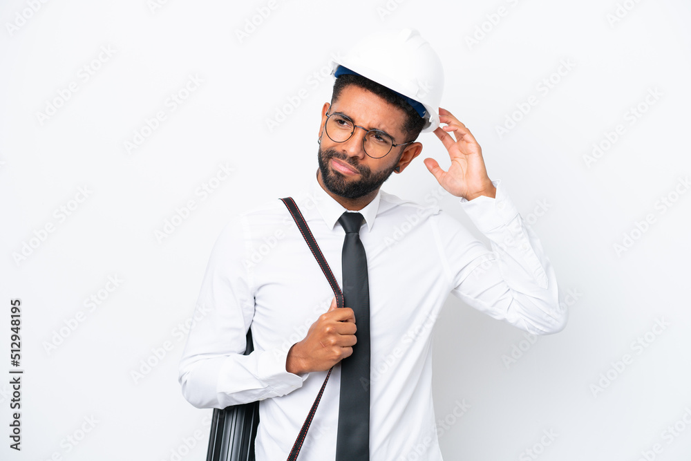 Young architect Brazilian man with helmet and holding blueprints isolated on white background having doubts Young architect Brazilian man with helmet and holding blueprints isolated on white background having doubts