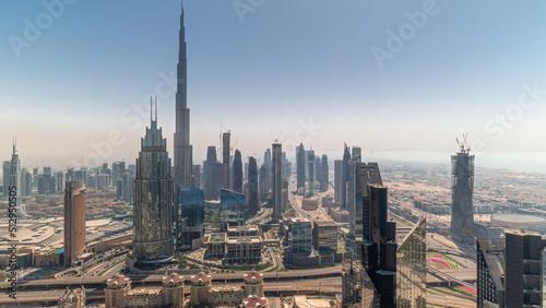 Aerial view of tallest towers in Dubai Downtown skyline and highway all day timelapse.