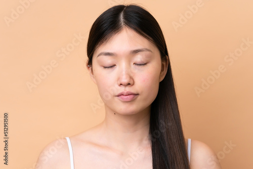 Young Chinese woman isolated on beige background . Portrait