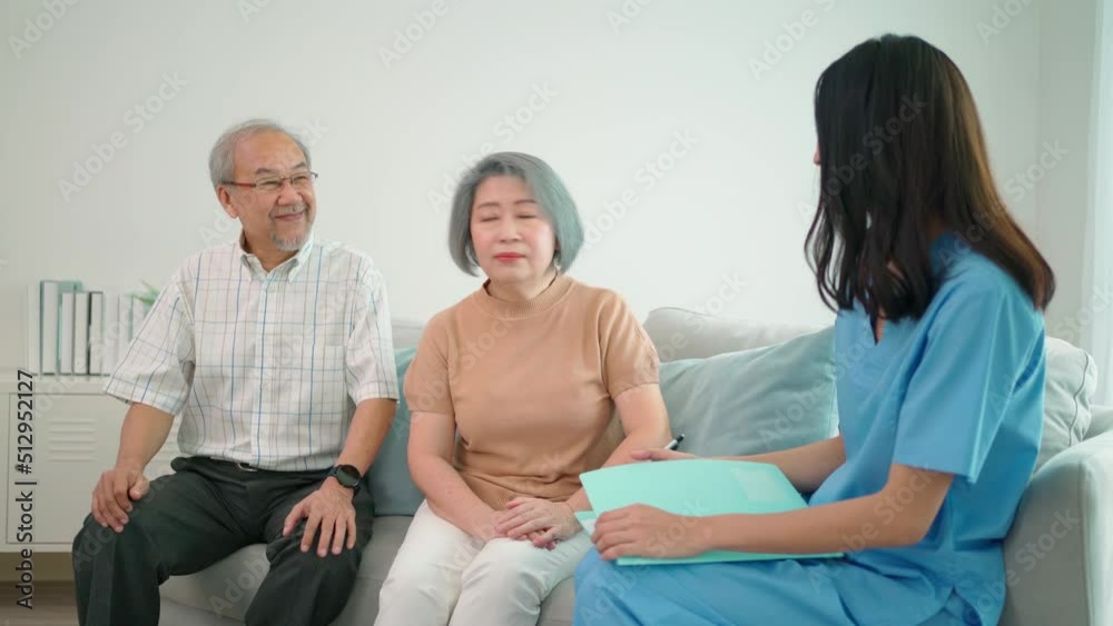 Young Asia female caregiver talking to elderly people who sitting on the sofa about symptoms at home. Pretty nurse doctor support and advise on elderly older mature patient. Healthcare and medical Young Asia female caregiver talking to elderly people who sitting on the sofa about symptoms at home. Pretty nurse doctor support and advise on elderly older mature patient. Healthcare and medical