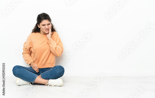 Teenager Russian girl sitting on the floor with toothache