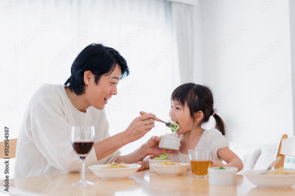 パパと一緒にご飯を食べる小さな女の子 パパと一緒にご飯を食べる小さな女の子