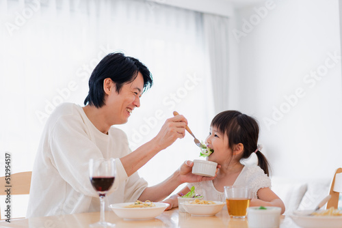 パパと一緒にご飯を食べる小さな女の子