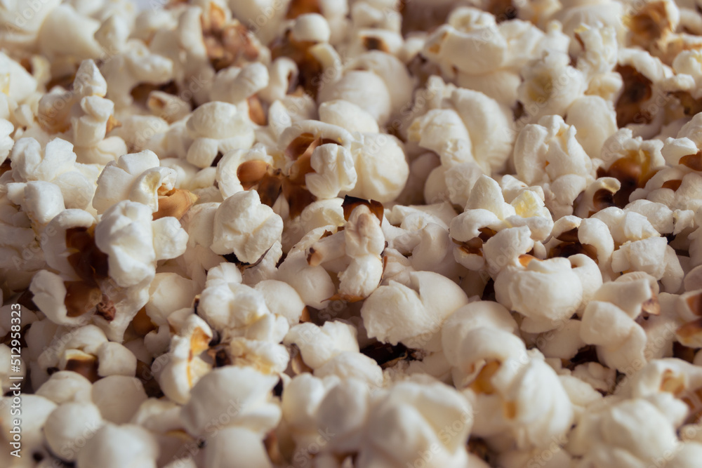 Buttered and sugared flakes of popcorn golden colors, close-up.