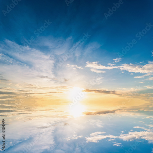 Sky blue and orange light of the sun through the clouds in the sky