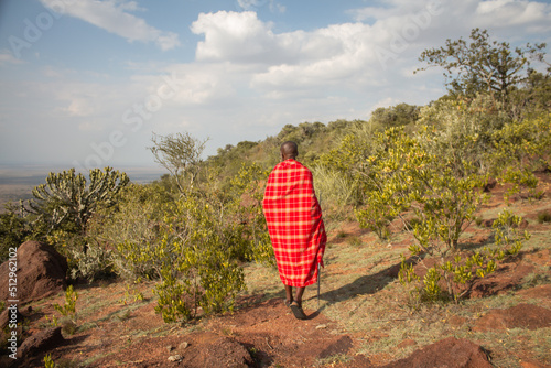Masai Warrior walking through savannah in Masai Mara Kenya