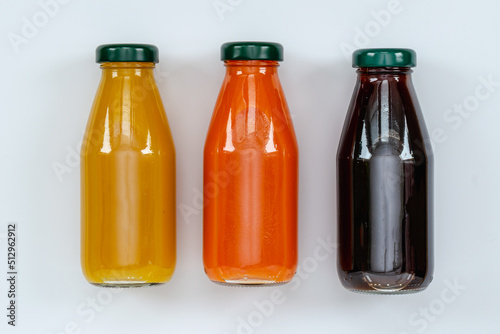orange, pomegranate juice, bottled carrot juice, top view on white background, healthy eating concept, vitamin diet