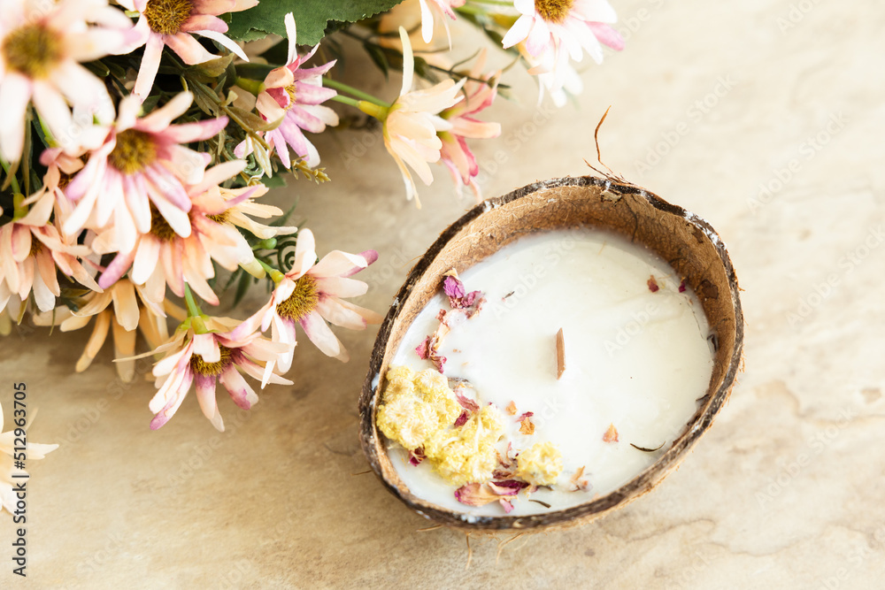 Handmade candle from soy and coconut wax in glass with wooden wick and dry flowers isolated on pastel beige background. Flat lay, top view, copy space Handmade candle from soy and coconut wax in glass with wooden wick and dry flowers isolated on pastel beige background. Flat lay, top view, copy space