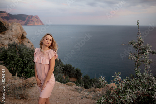 Beautiful and style woman walking in the nature, dressed in fashion dress and ebjoy the evening time of the summer