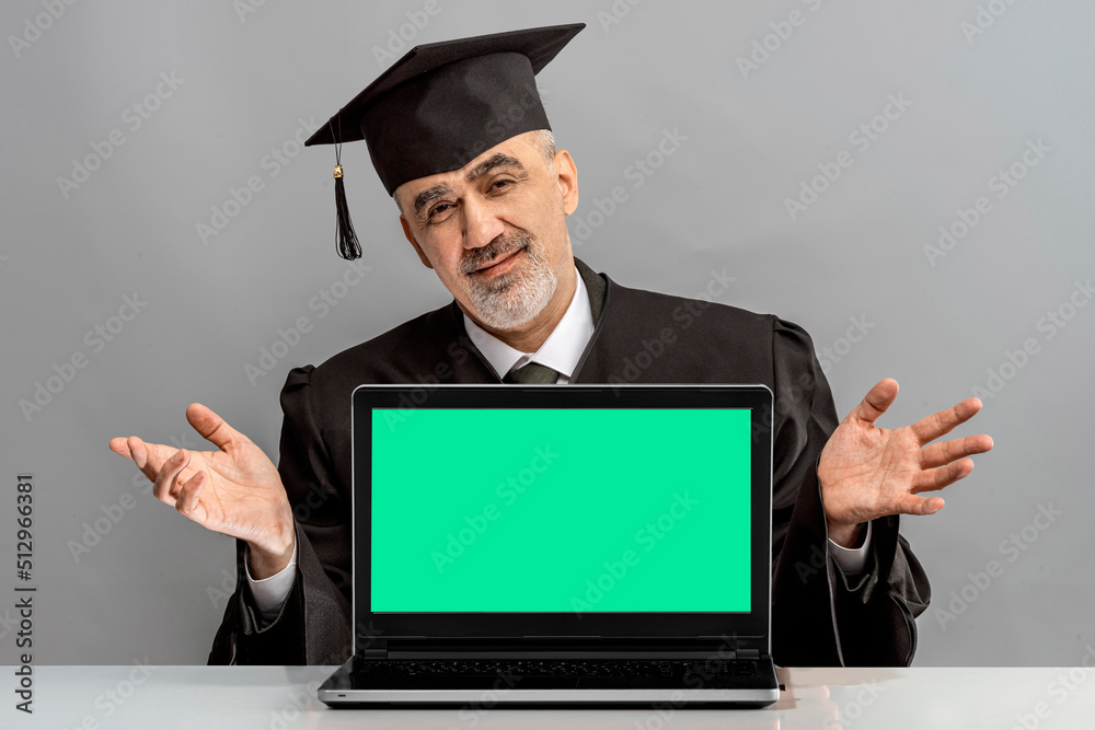 Academician, Professor with laptop.Concept of online education e-learning at the university, college. Prof is wearing a cap with Tassel and gown. Senior educator or Doctor of Philosophy, learned man Academician, Professor with laptop.Concept of online education e-learning at the university, college. Prof is wearing a cap with Tassel and gown. Senior educator or Doctor of Philosophy, learned man