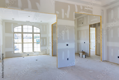 The finishing putty is being applied to the walls of an empty apartment to prepare for painting a newly constructed house