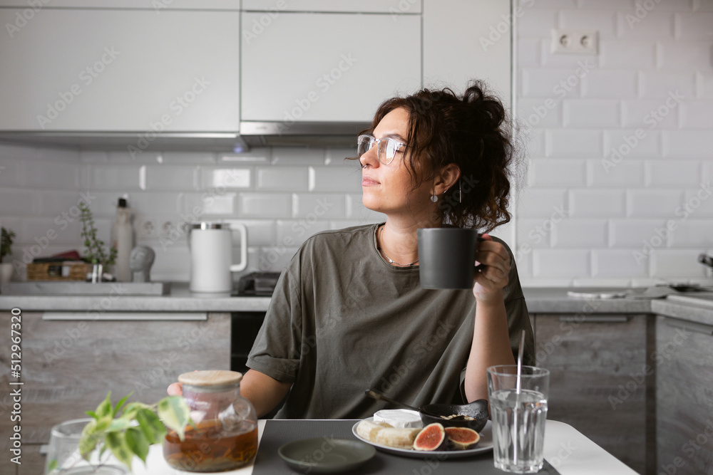 beautiful girl in glasses with curly hair eating breakfast on the kitchen , early morning mood, morning snacks, healthy life, healthy food, healthy breakfast beautiful girl in glasses with curly hair eating breakfast on the kitchen , early morning mood, morning snacks, healthy life, healthy food, healthy breakfast