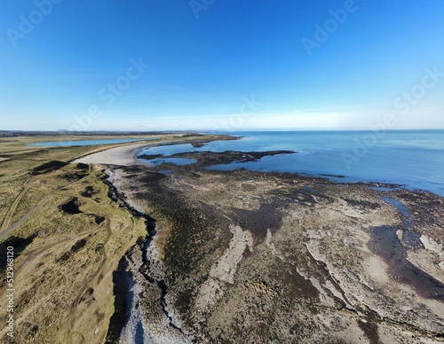 Aerial view of the incredible coastline of Scotland with views of the North Sea. Blue sky background with ocean waves. 
