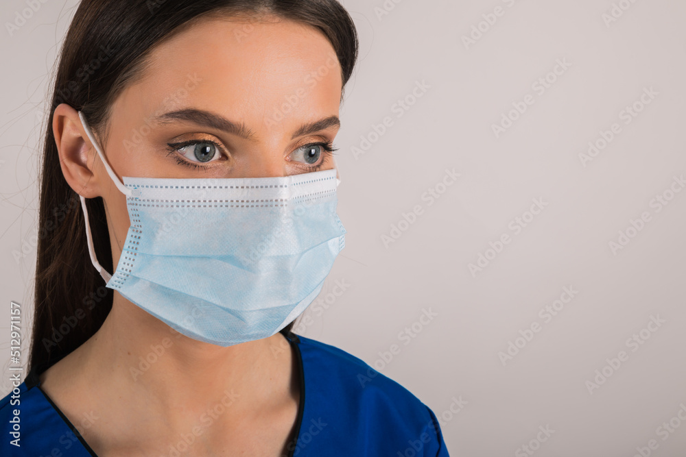portrait of young female doctor in medical mask looking at left. portrait of young female doctor in medical mask looking at left.