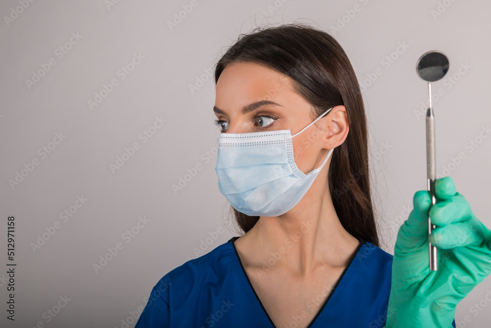 Woman dentist holding tools looking to the side. Woman dentist holding tools looking to the side.