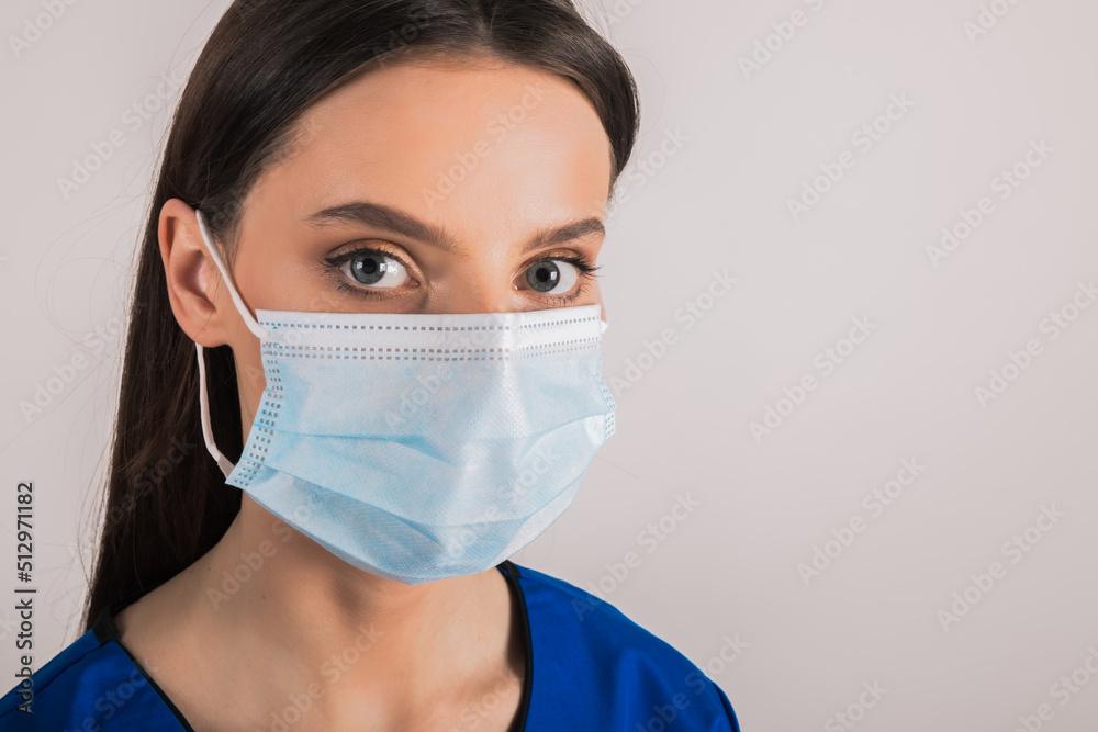 portrait of young female doctor in medical mask looking at camera. portrait of young female doctor in medical mask looking at camera.
