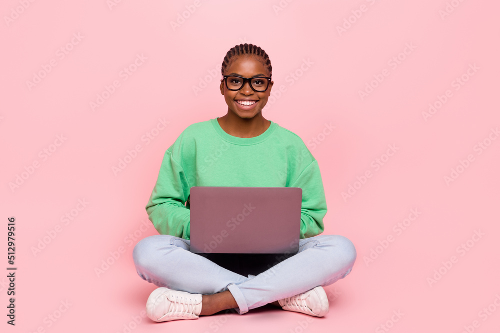 Full body portrait of cheerful girl sit floor hold use wireless netbook isolated on pink color background