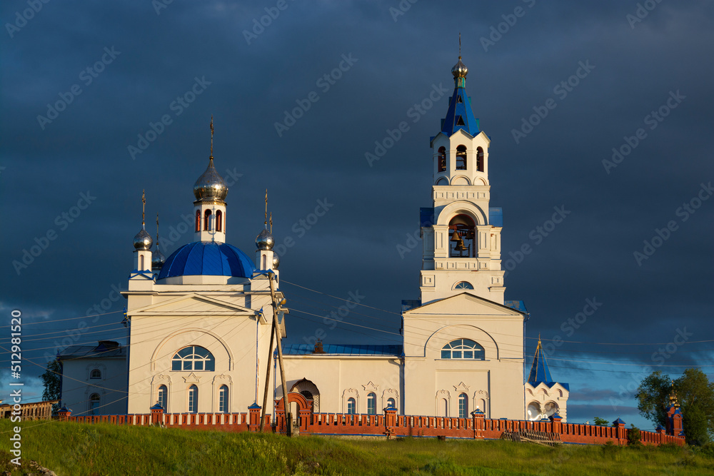 an old Orthodox church on the river bank.sunset sun and black clouds. an old Orthodox church on the river bank.sunset sun and black clouds.