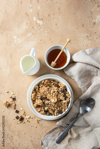 Brealfast cocnept. Natural muesli with unprocessed whole grains, chia, quinoa, nuts, seeds with chocolate slices served with mik and  honey. photo