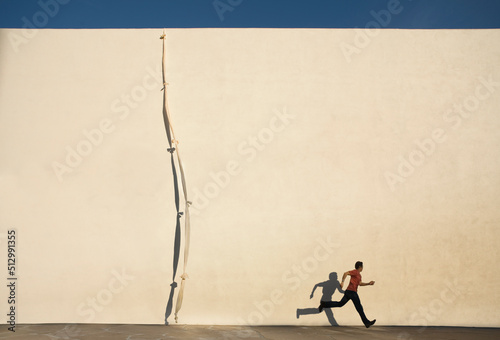 Man escaping by climbing rope over wall photo