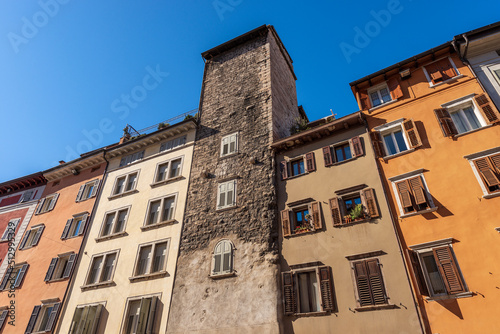 Close-up of a medieval tower and old houses in Trento downtown (via Rodolfo Belenzani), the main street of the city in the center. Trentino Alto Adige, Italy, Europe. photo