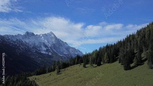 Cinematic aerial view from a drone flight over the alm paradise of the Gais Valley with snowcovered peaks behind, located in Austria photo