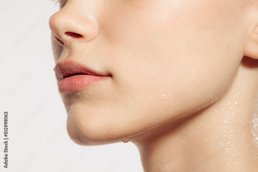Fototapeta premium Closeup female lips, cheeks and nose isolated over white studio background. Concept of cosmetology, skincare, cosmetics, plastic surgery, ad