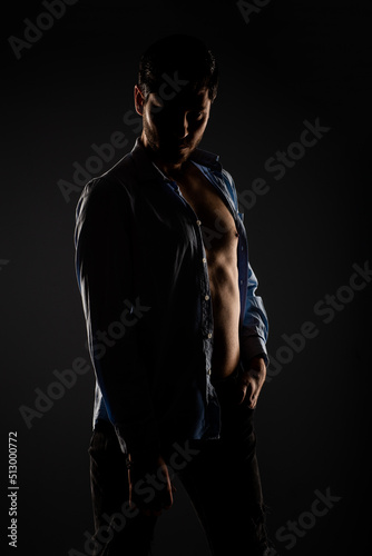 Male model posing in a light dimmed room