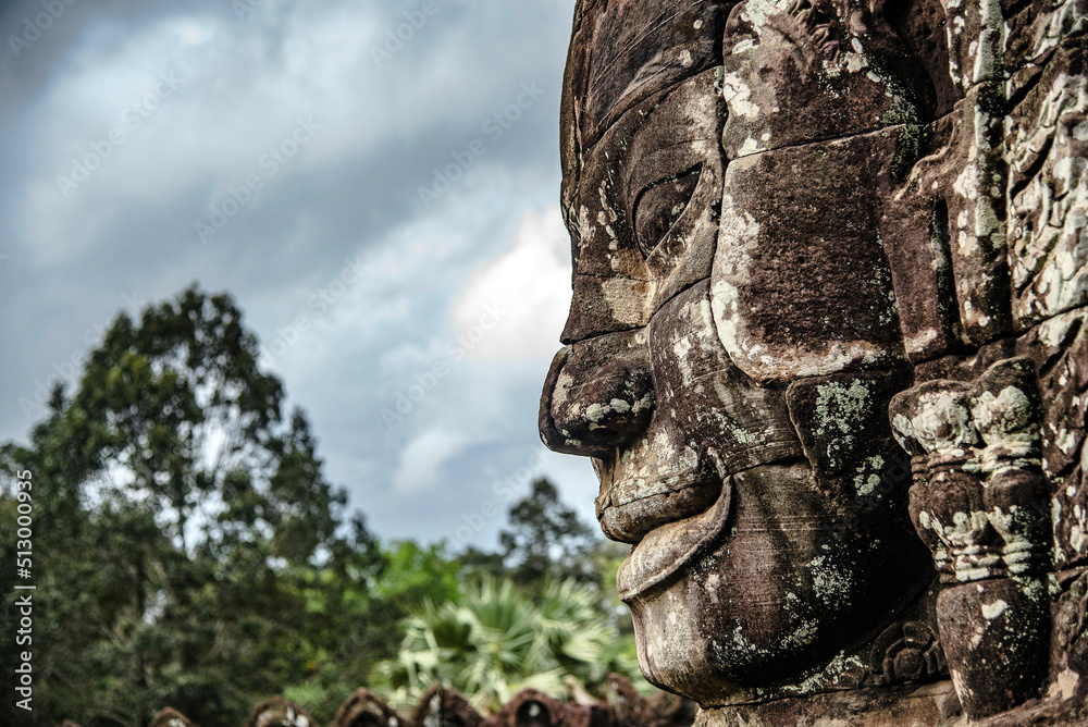 A large figure carved face on sandstone in the pagoda of Bayon Angkor Thom Temple, Siem Reap, Cambodia.