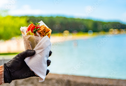 Greek street food gyros in man hand outdoor