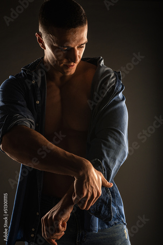 Fixing his sleeves and posing in studio, close up