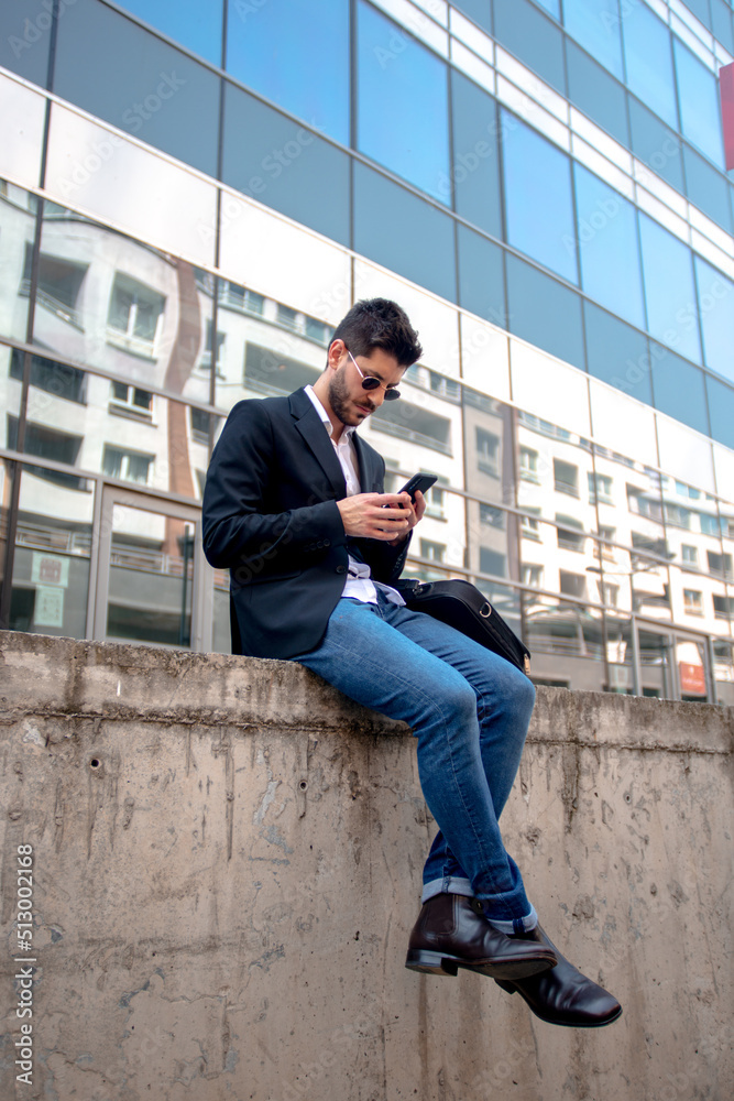 Looking at his phone while sitting Looking at his phone while sitting