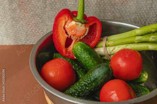 Canvastavla Vegetables lie in a metal bowl: tomatoes, asparagus, cucumbers, red bell peppers