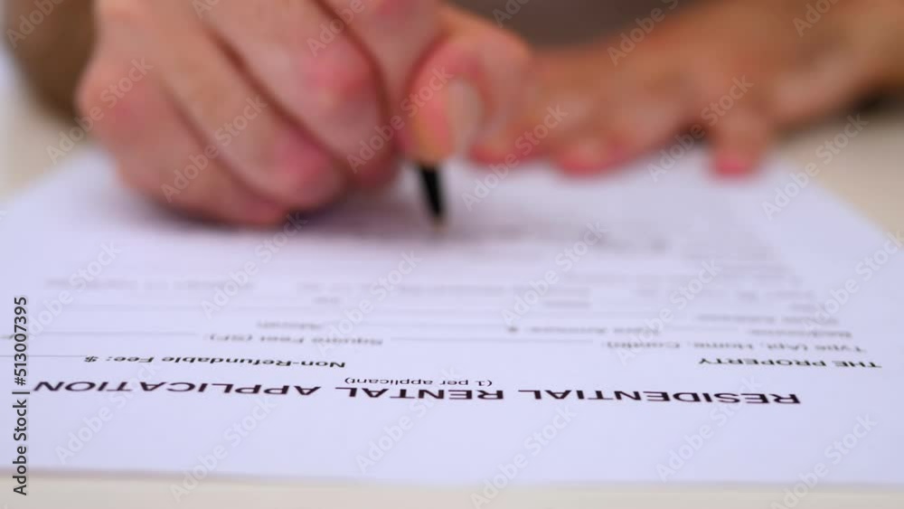 hand of man enters data in the residential rental application in the US