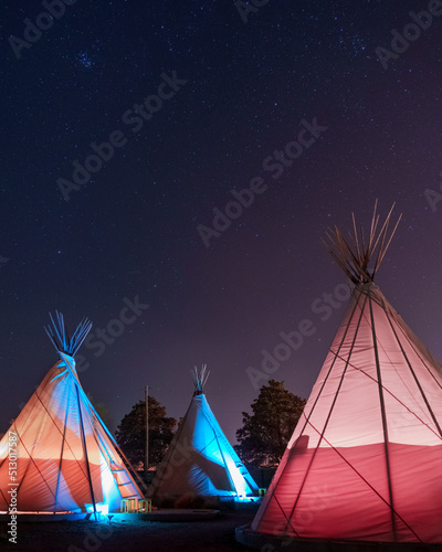 Teepees glowing under a starry sky at night in Marfa, Texas photo